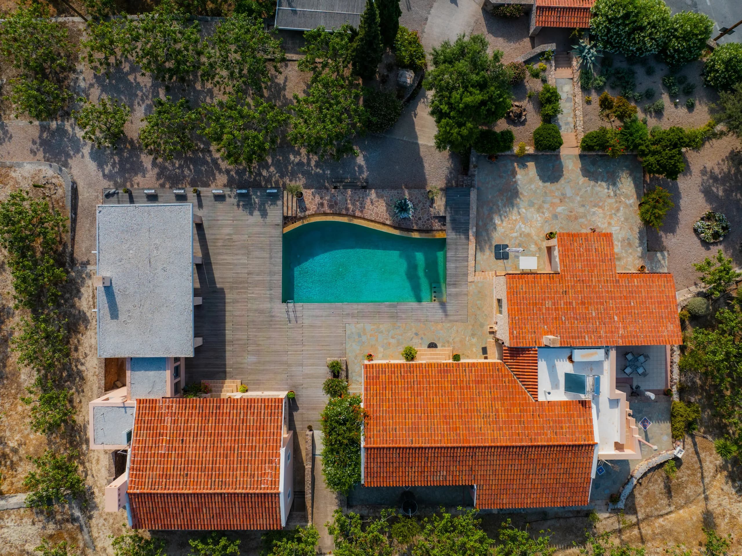 Aerial view of a villa with a pool and terracotta roofs