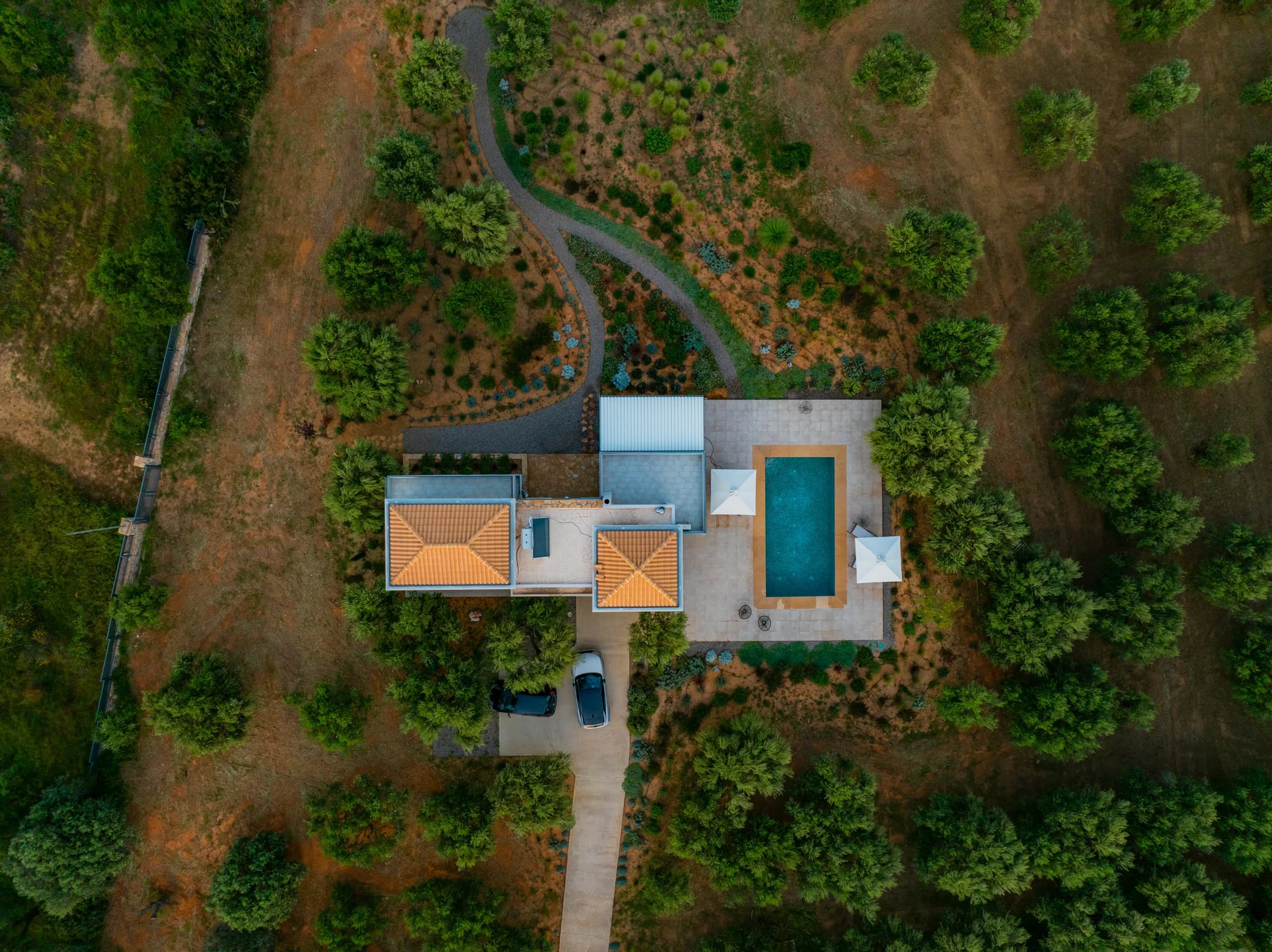 Aerial view of a villa with a pool surrounded by greenery