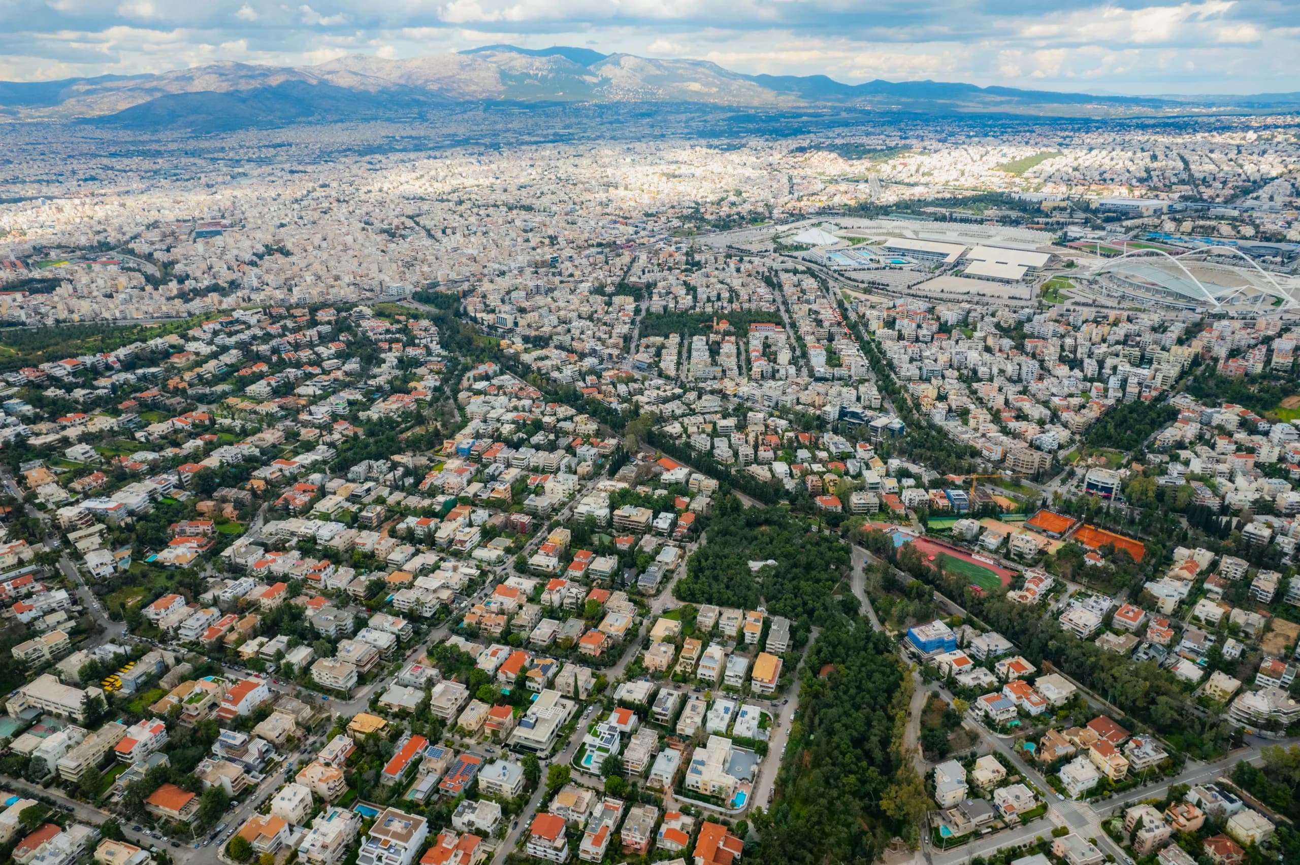 Aerial view of the Athens suburbs stretching to the mountains