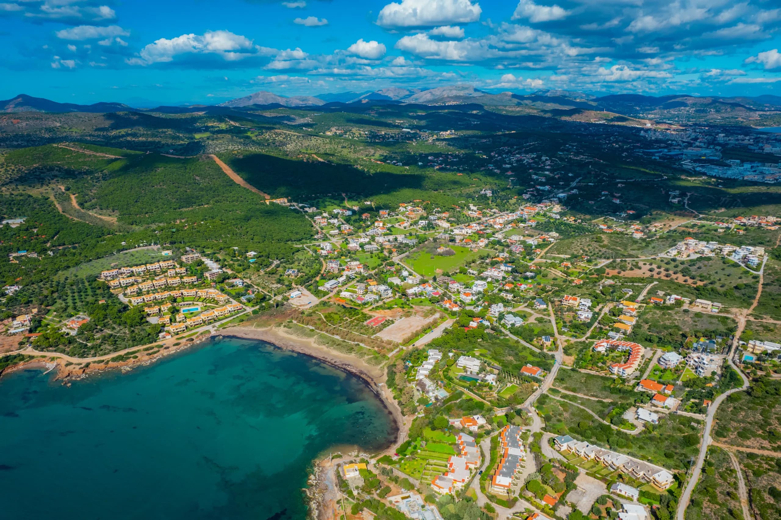Aerial view of a bay with clear turquoise water and low houses