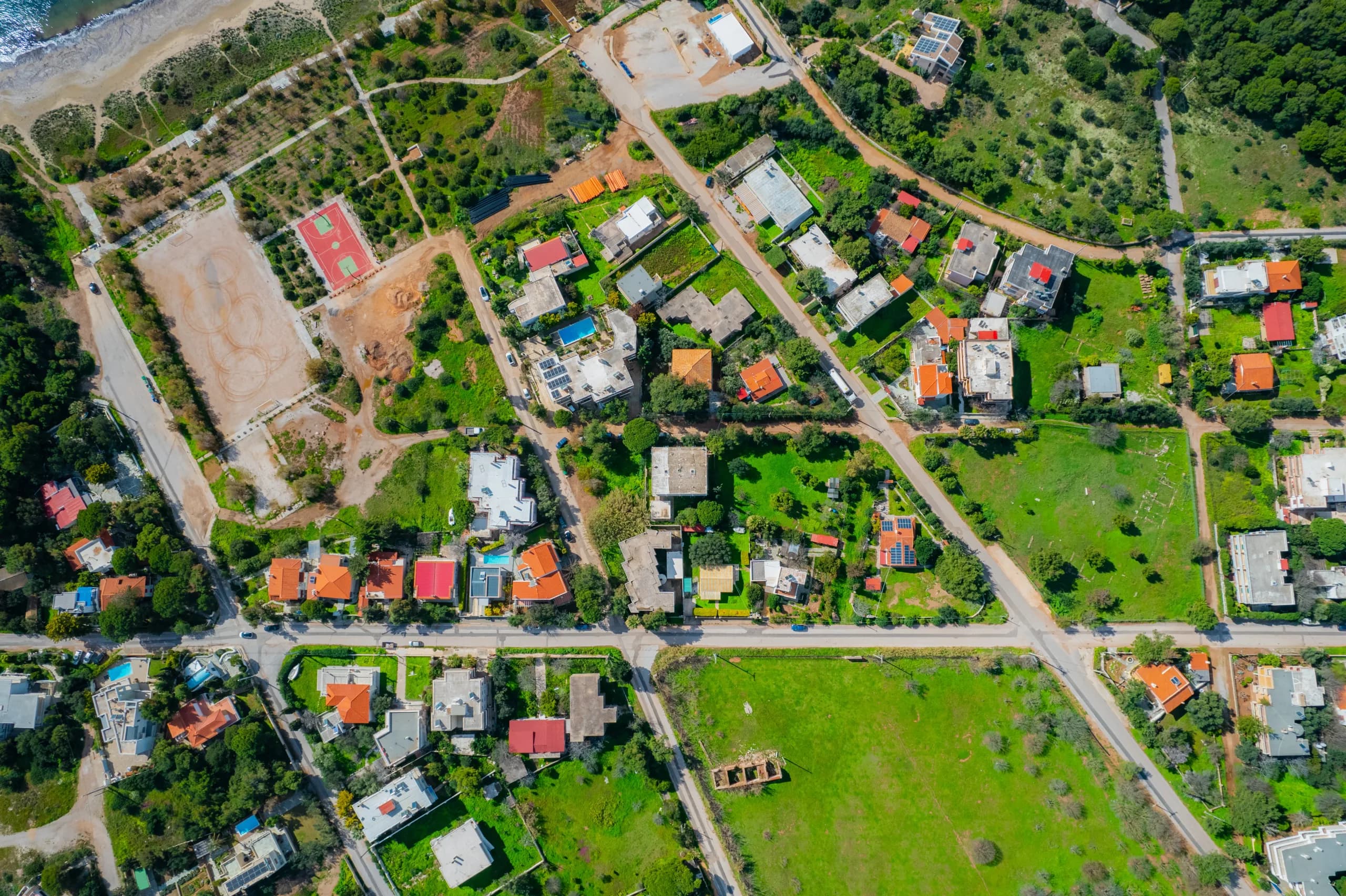 Aerial view of a residential area with villas, gardens and pools