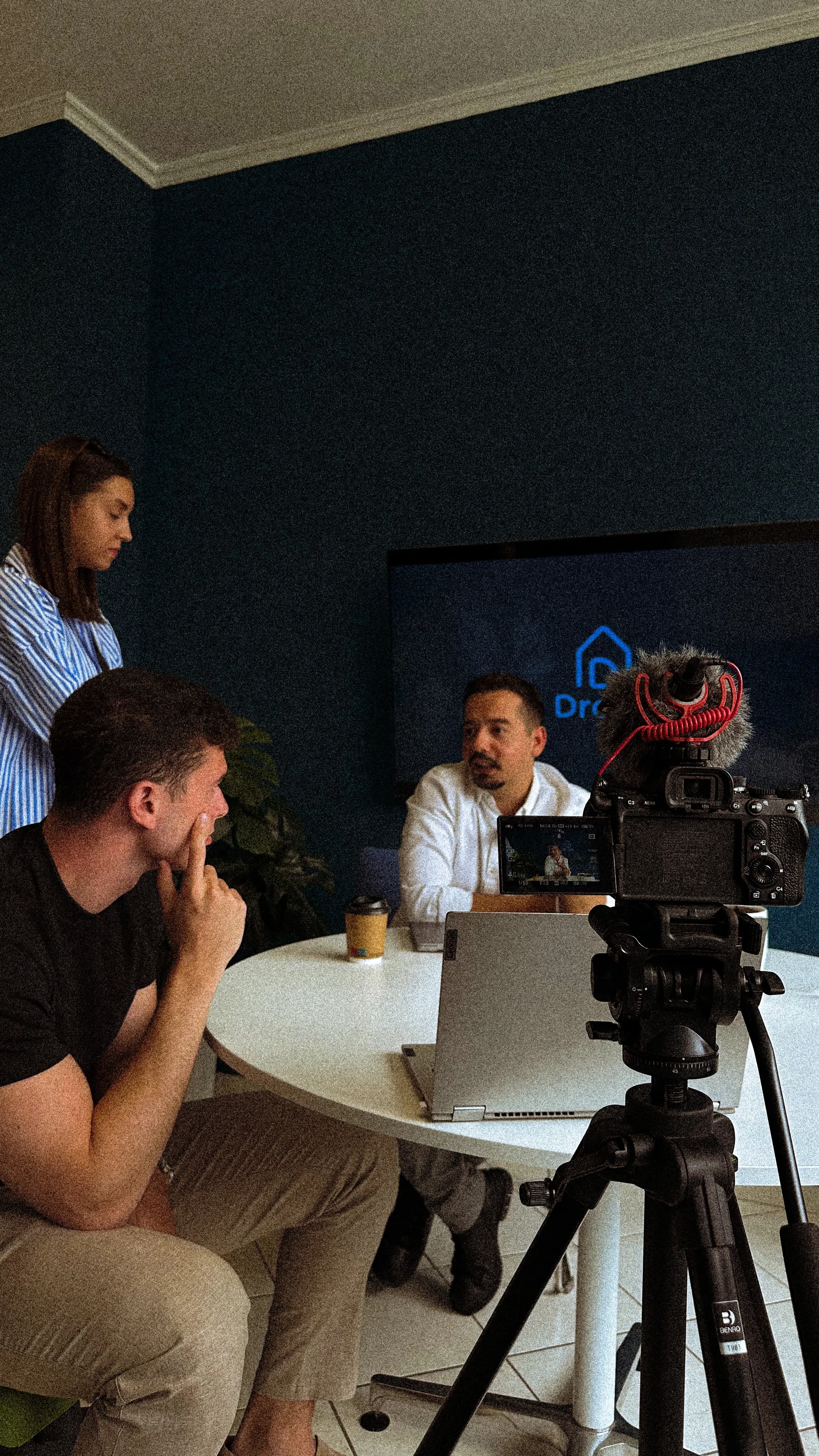 Two people recording an interview in front of a camera and monitor