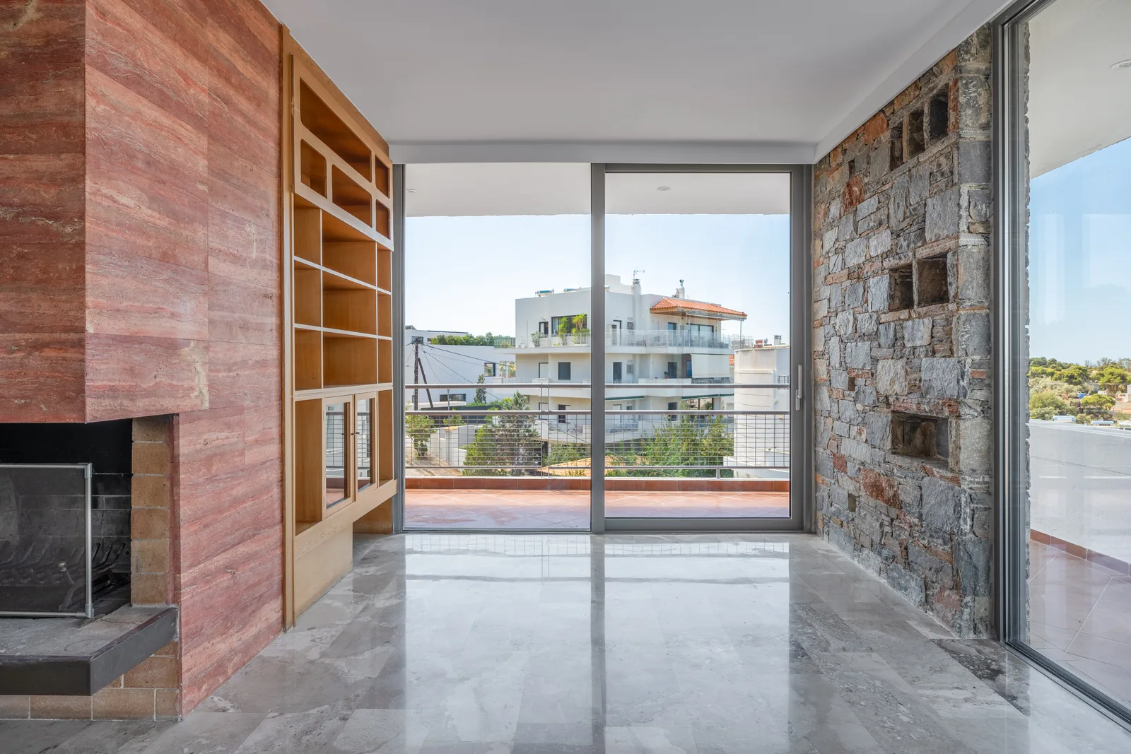 Room with an exposed stone wall and sliding doors onto a balcony