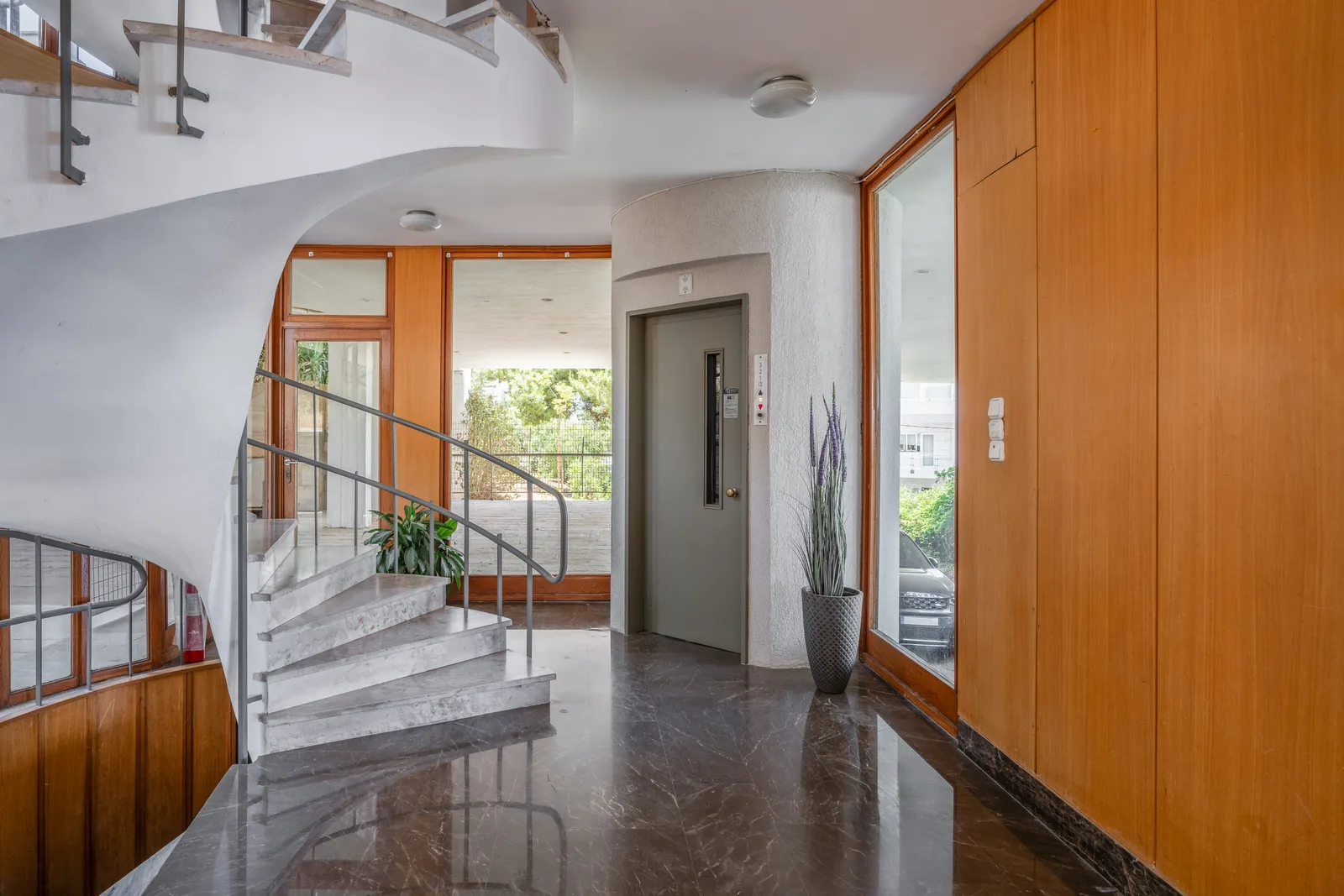 Entrance hall with a marble staircase and a lift